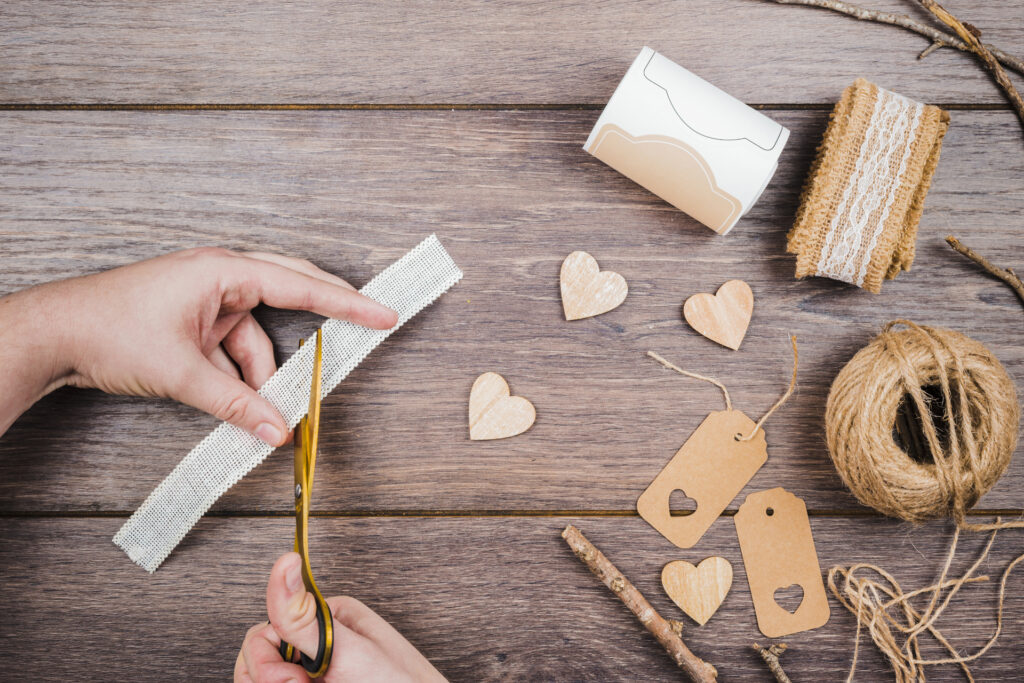close-up-person-cutting-lace-with-knife-wooden-desk
